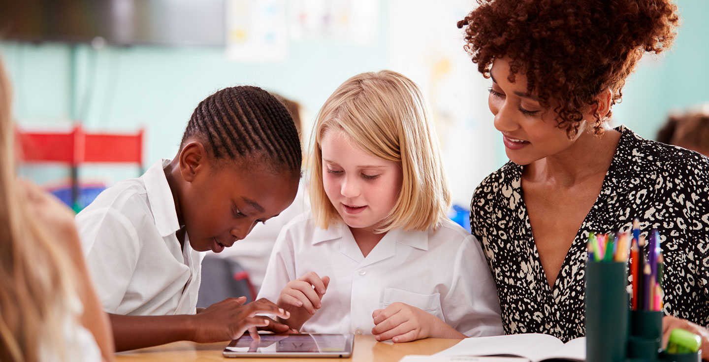 teacher working with two students at a table