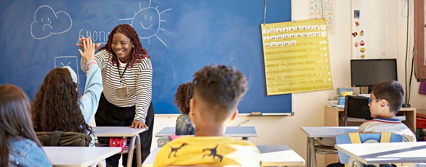 teacher giving student a high five in a classroom