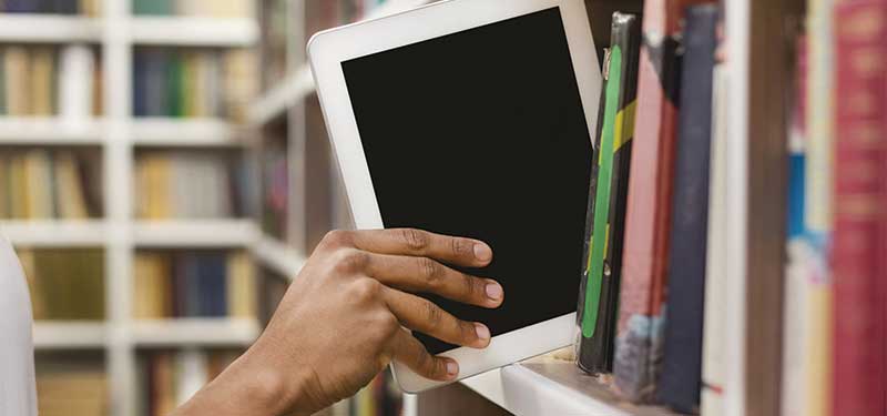 Ipad being pulled off of a library shelf