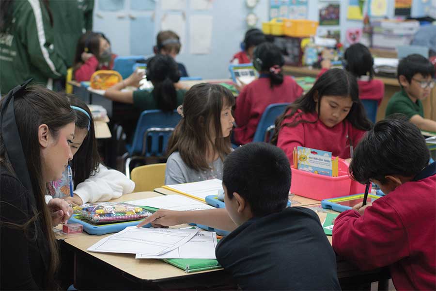 Teacher sitting at a table with students