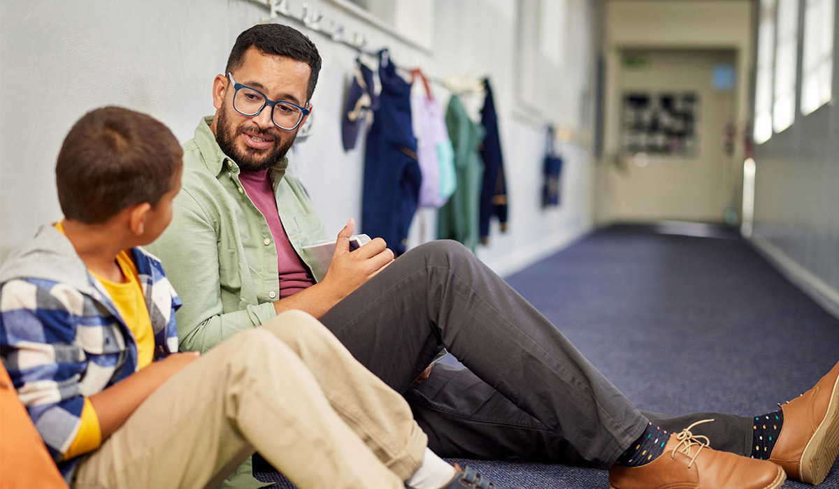 Educator speaking with a student in the hall
