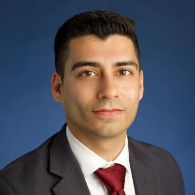 square headshot of a man on a blue background