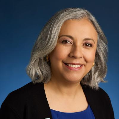 headshot of a woman on a blue background