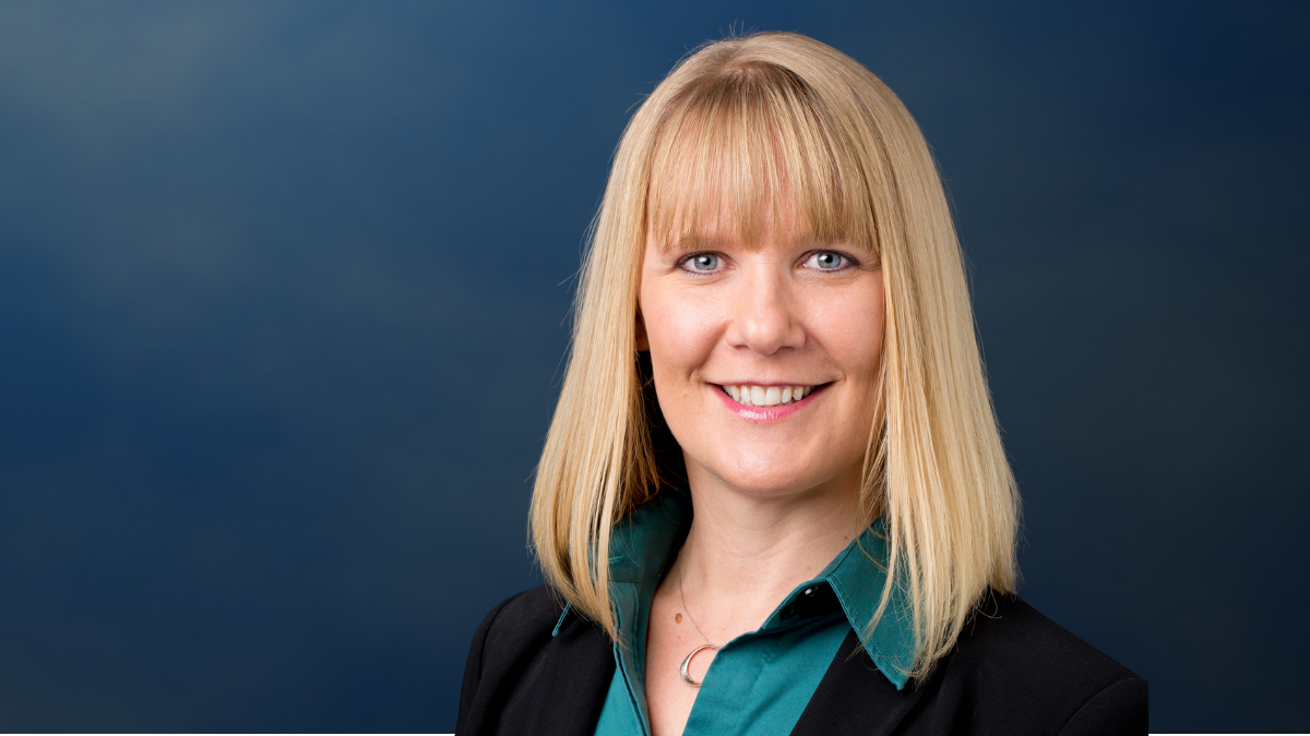 headshot of a woman against a blue background