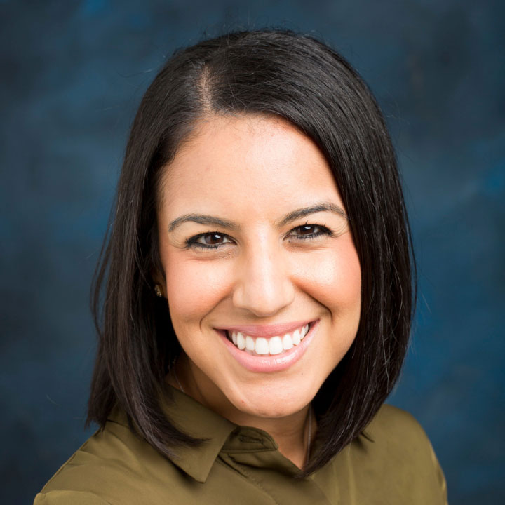 headshot of a woman on a blue background