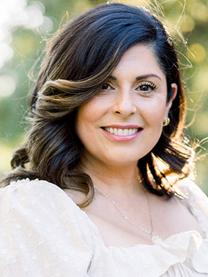 Adriana Abich Portrait Dark Haired Woman in white posing outside
