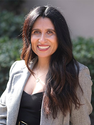 Lara Mayra portrait dark haired woman in grey blazer posing outside