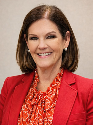 Mary Grace ONeill Portrait woman with brown shoulder length hair in red