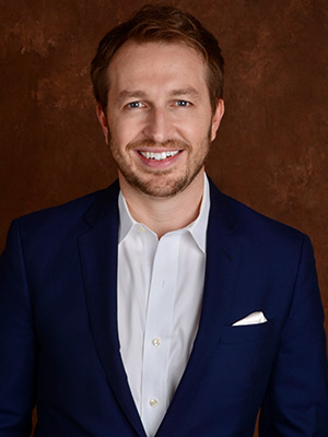 Nick Melvoin Portrait, man in blue suit in front of a brown background