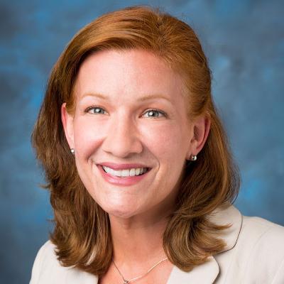 headshot of a woman on a blue background