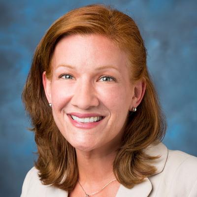 headshot of a woman on a blue background