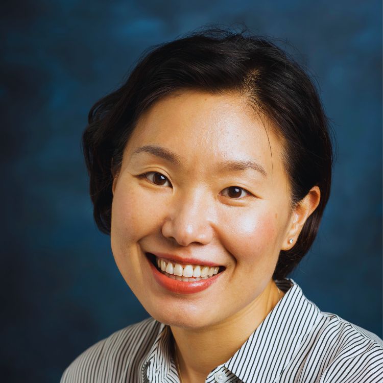 headshot of a woman on a blue background