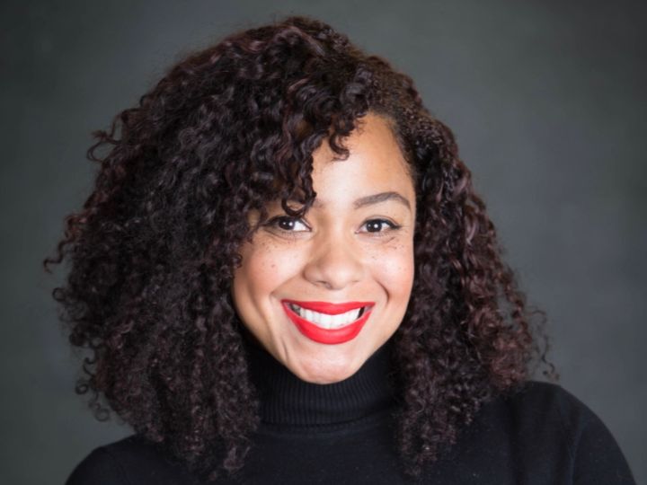 picture of a woman with curly hair on a dark gray background