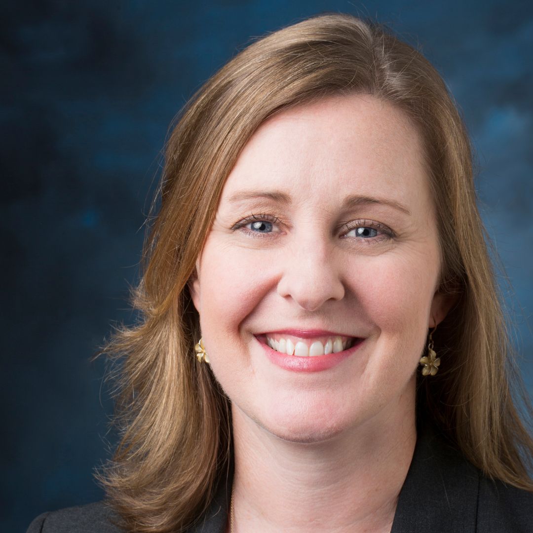 headshot of a woman on a blue background