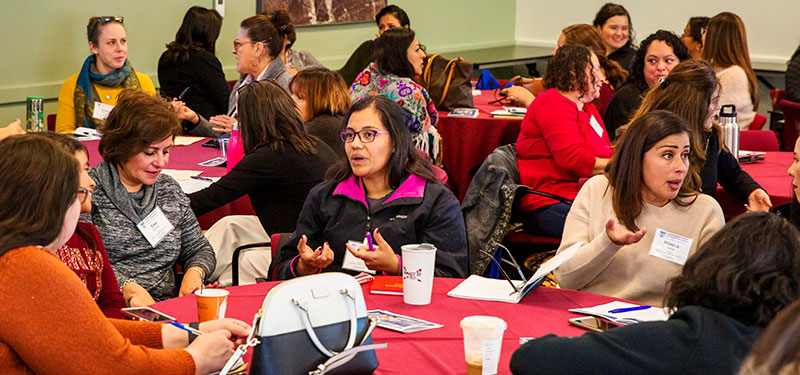 picture of Latina/o people sitting at round tables at a conference