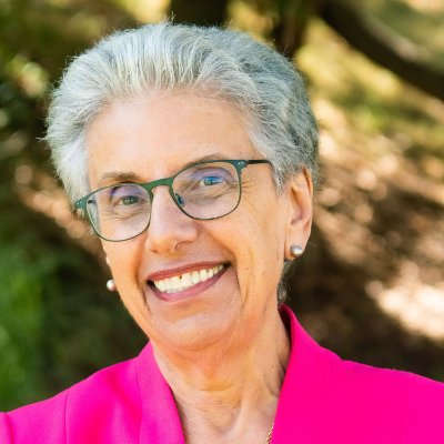 headshot of a woman wearing a hot pink jacket