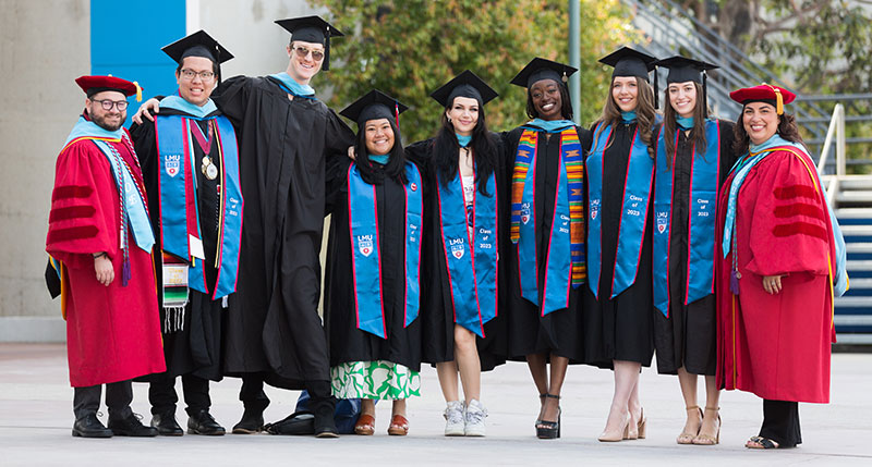 group of graduate students and their advisors and faculty at commencement and wearing regalia